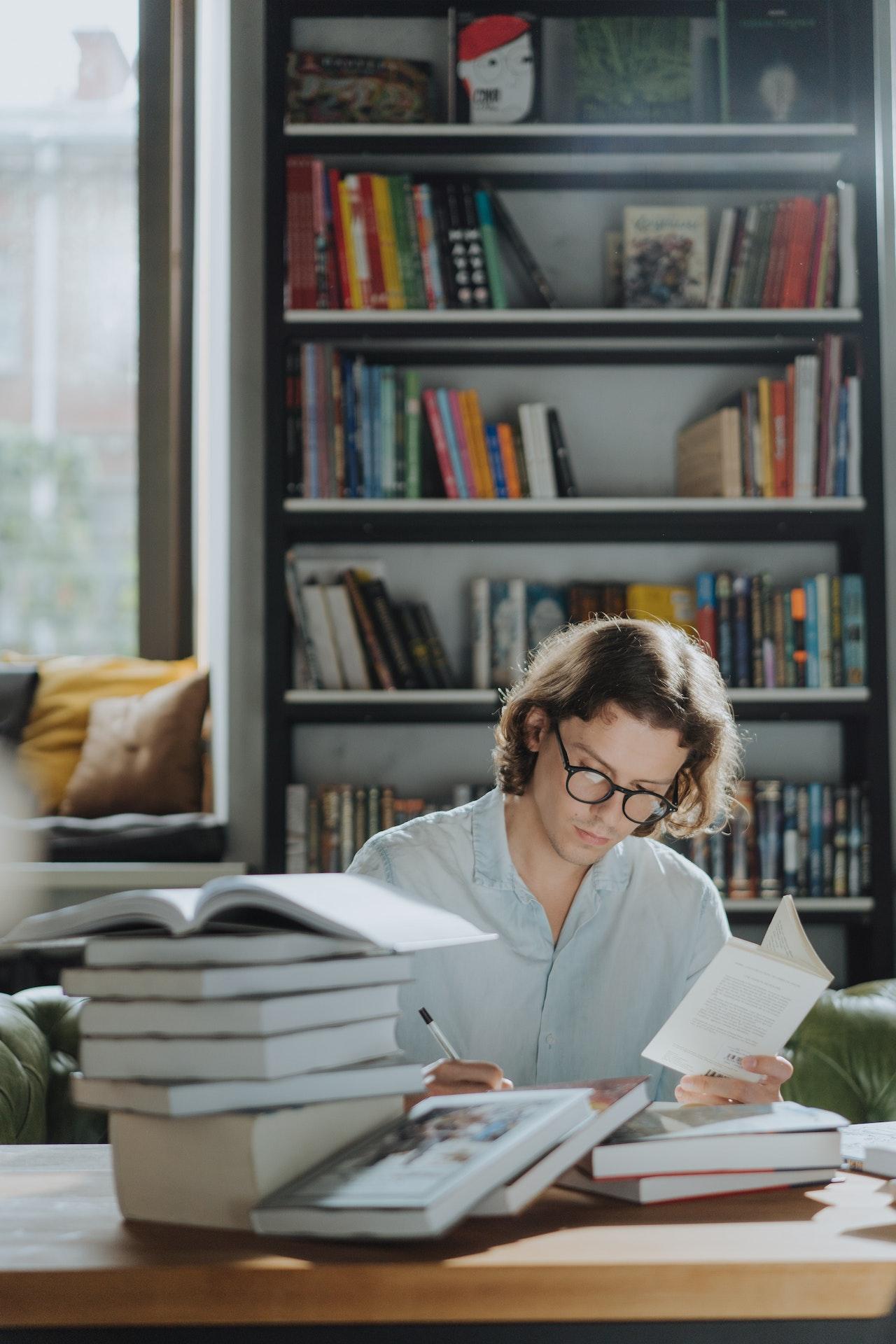 A Men reads books at a table